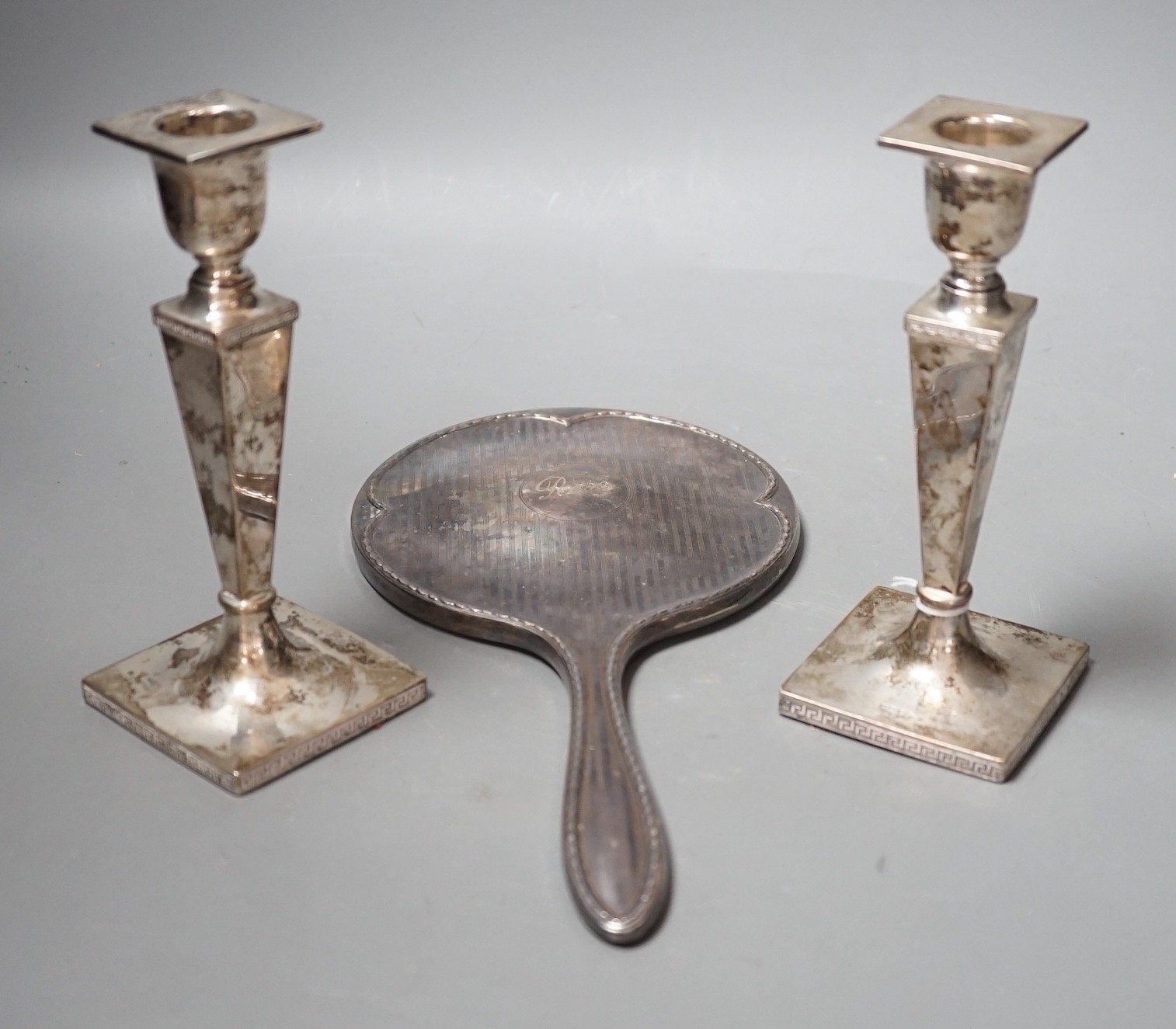 A pair of George V silver candlesticks, with tapering stems, Walker & Hall, Sheffield, 1915, 16.4cm, weighted and a 1920's silver mounted hand mirror.